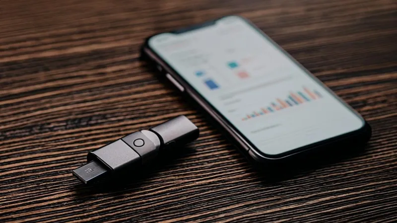 Hardware wallet beside a smartphone showing a crypto portfolio app