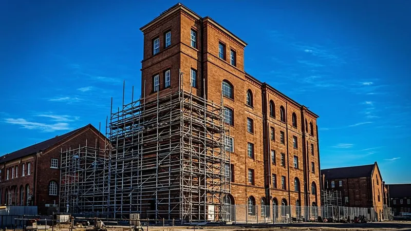 Historic brick warehouse under renovation with scaffolding in a rural zone