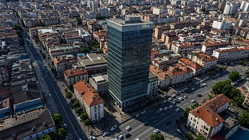 Aerial view of an urban block mixing older buildings with one new glass tower